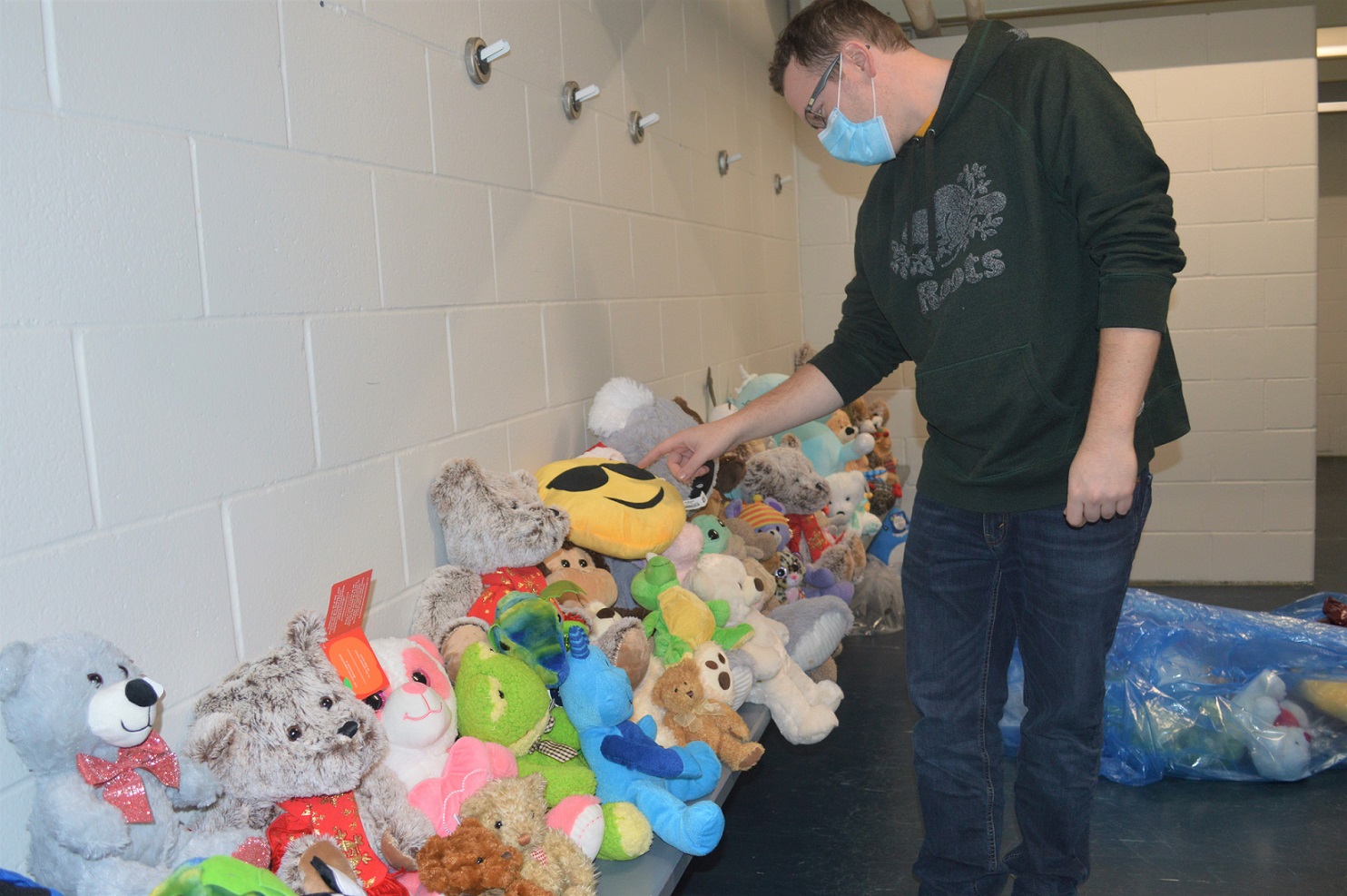 Ryan Olejnik, from the Dorchester Lion's Club, counts the stuffed animals collected from the Teddy Bear Toss during the Dorchester Dolphins' game against Exeter. Over 230 stuffed animals were collected. <i> (photo / Rob J. Ross) </i> action